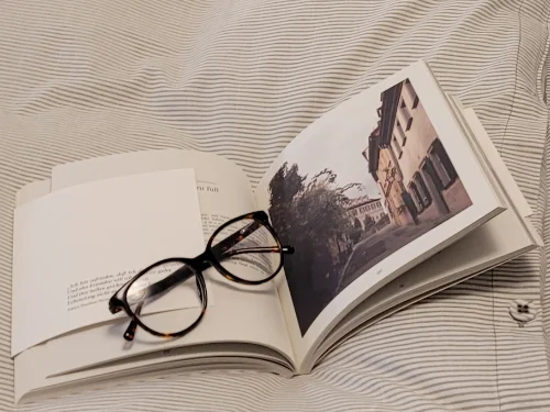 Buch und Brille auf Bettdecke