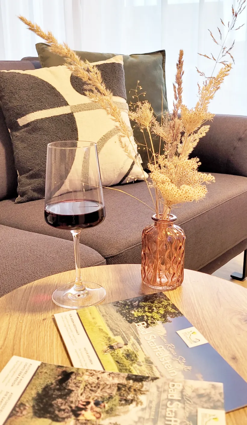 Wein mit Deko auf Tisch vor Sofa